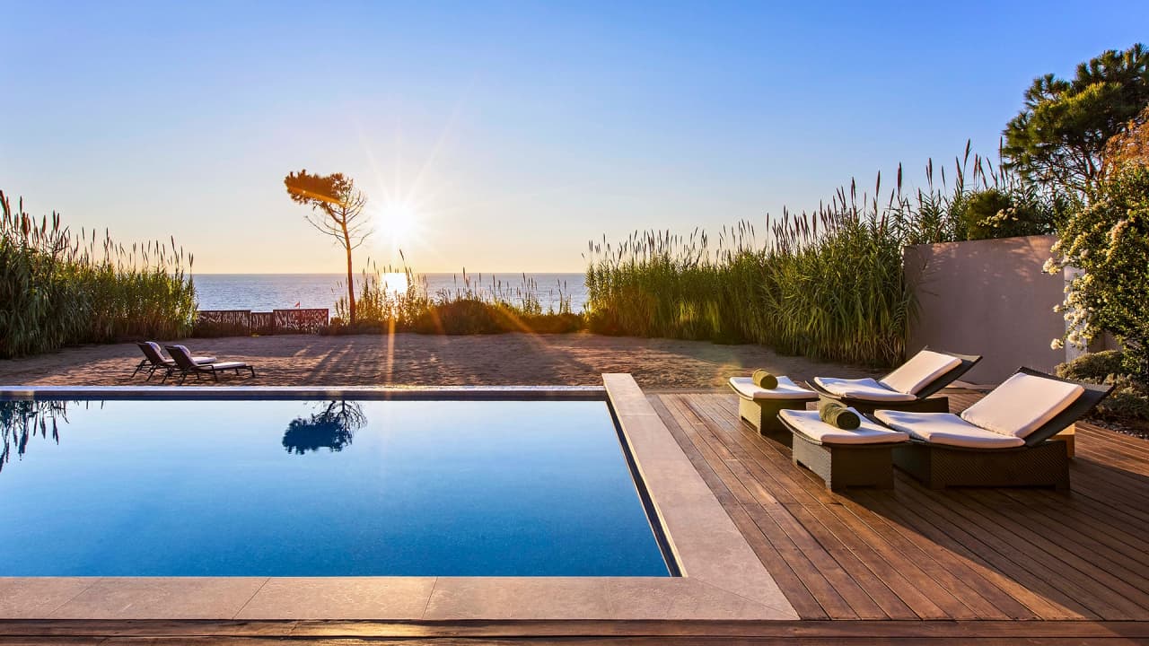 A pool at The Romanos at sunset, Costa Navarino