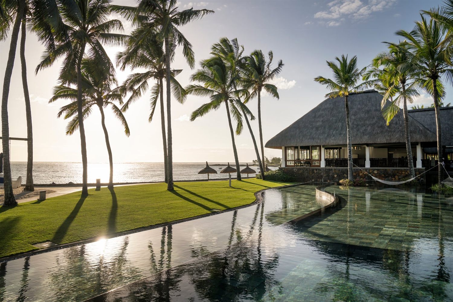 Palm trees and the beachfront pool at Constance Belle Mare Plage, Mauritius